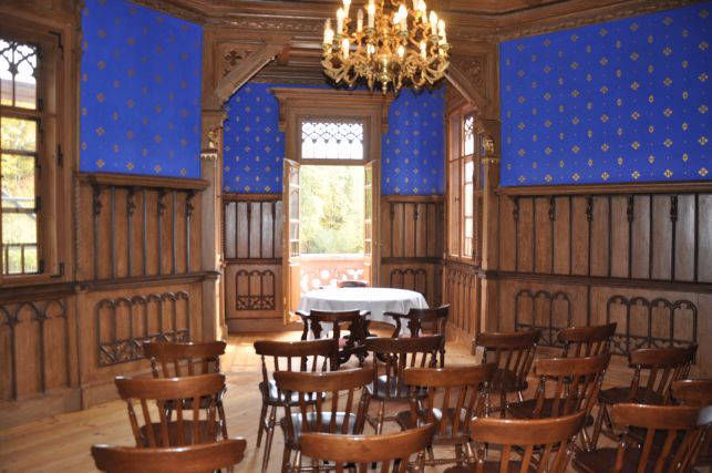 Blauer Saal mit Kronleuchter und Stuhlreihen