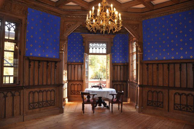 Historischer Innenraum mit Kronleuchter und gedecktem Tisch im Erker