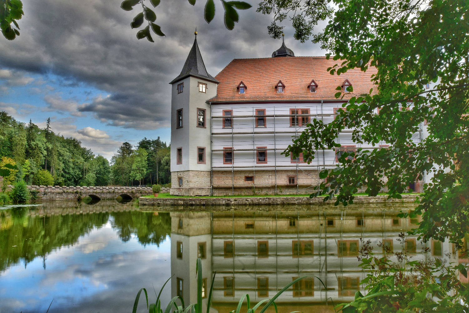 Schloss Wolfersdorf spiegelt sich im künstlich angestauten Teich